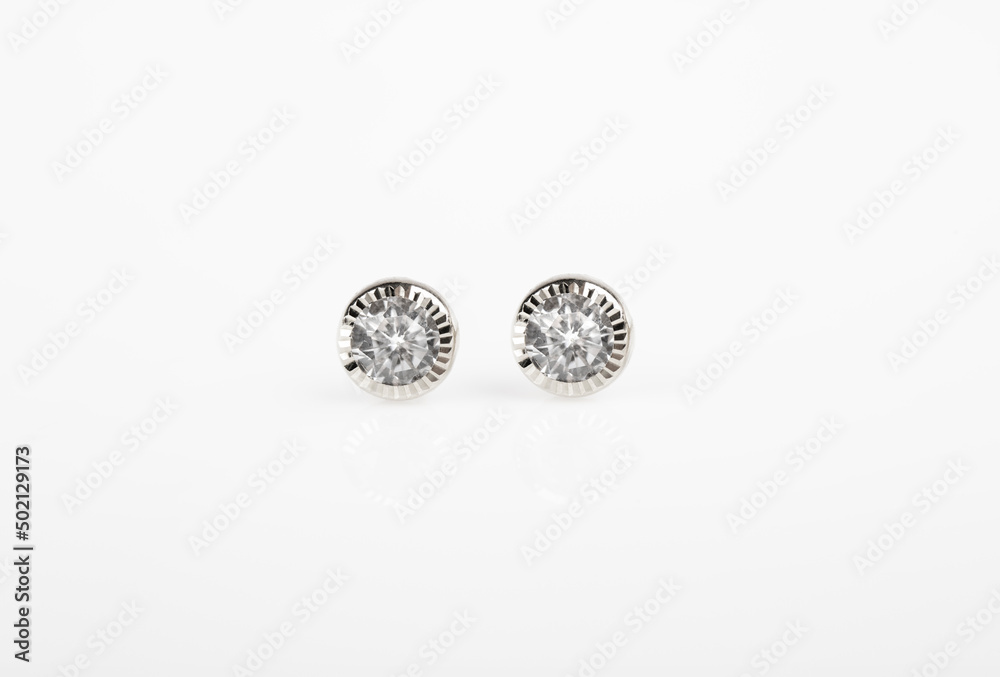 Round silver stud earrings with diamond on white background. Round silver stud earrings with diamond on white background.