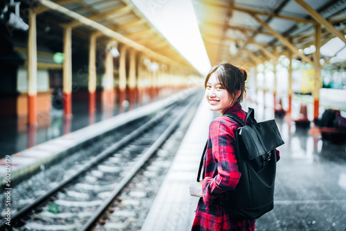 summer, relax, vacation, travel, portrait of cute Asian girl showing smile and showing joy while waiting at the train station for a summer trip.