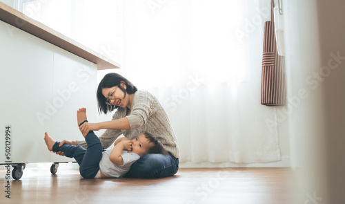 Japanese mother playing with little cute boy on floor at home, Happy Asian Family having Fun indoors.