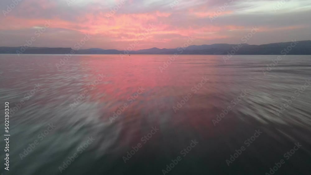 Drone flight over sea, sunset aerial shot slide ocean surface in sunrise golden hour. Dynamic shot with cinematic camera tilt, sun on horizont, pink sky Drone flight over sea, sunset aerial shot slide ocean surface in sunrise golden hour. Dynamic shot with cinematic camera tilt, sun on horizont, pink sky