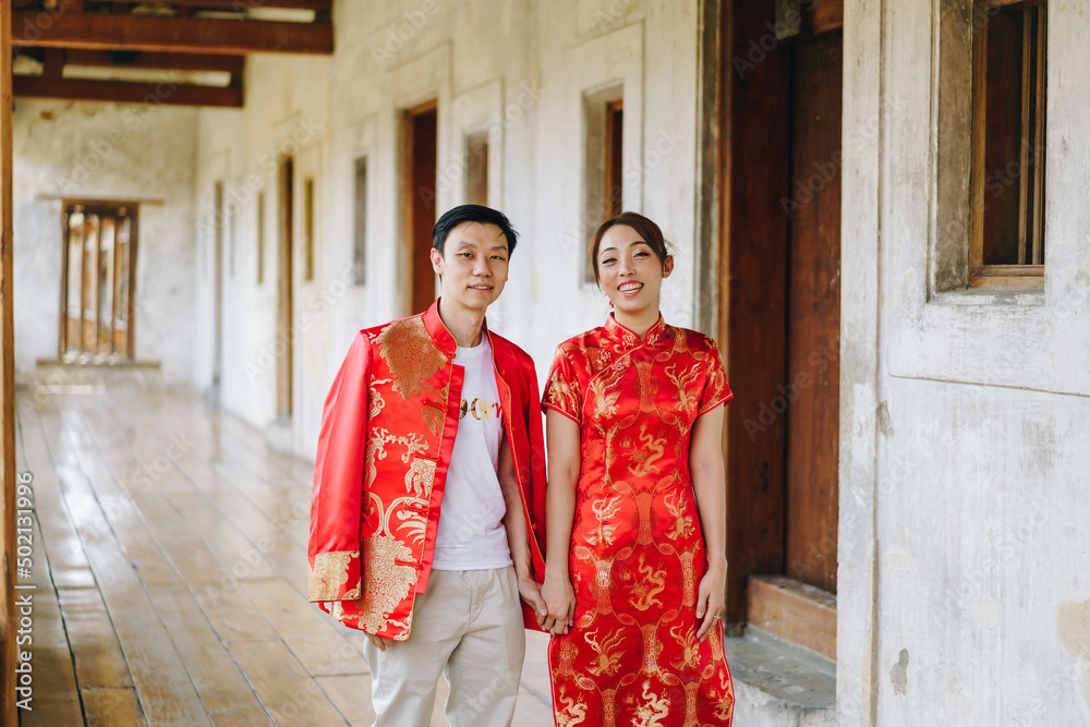 Happy young Asian couple in Chinese traditional dresses