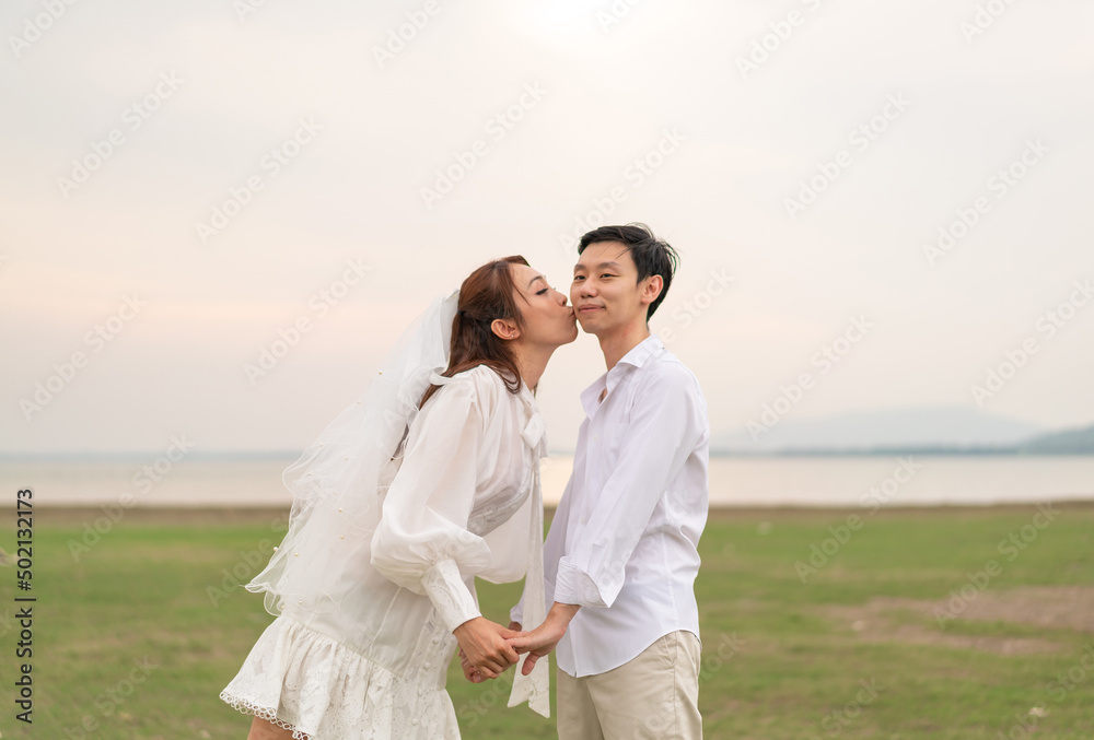 Happy young Asian couple in bride and groom clothing Happy young Asian couple in bride and groom clothing