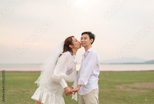 Happy young Asian couple in bride and groom clothing