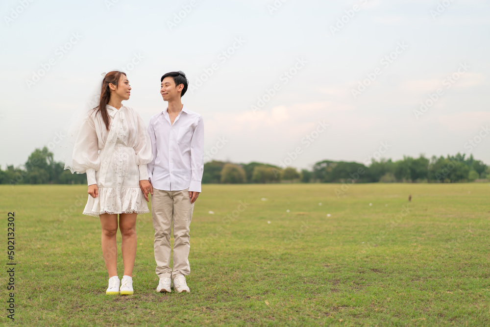 Happy young Asian couple in bride and groom clothing Happy young Asian couple in bride and groom clothing