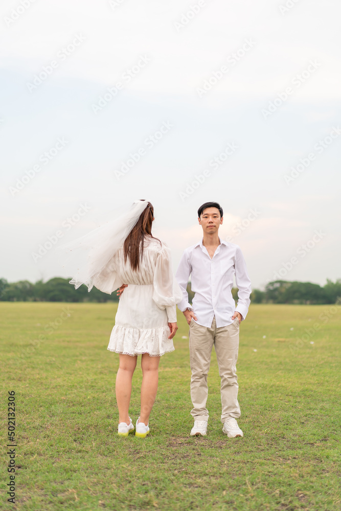 Happy young Asian couple in bride and groom clothing Happy young Asian couple in bride and groom clothing