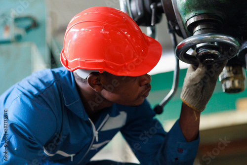 Black Male Engineer Working on machine in Factory. black man engineer checking Quality control the machine. Service and Maintenance of factory machinery. American African people.