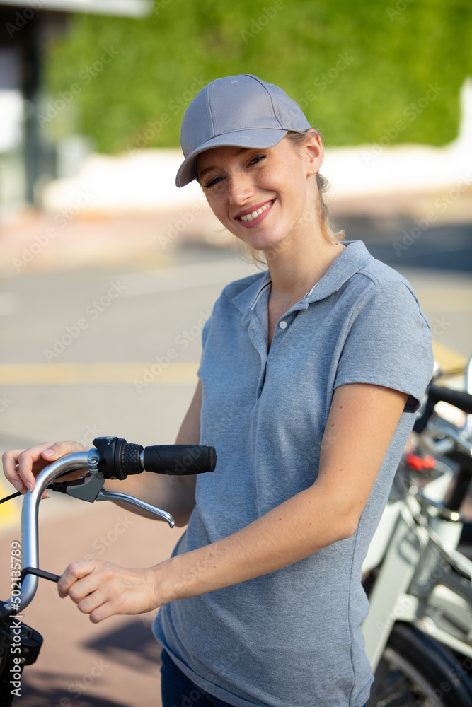 Naklejka premium young happy positive woman master is repairing bicycle in workshop