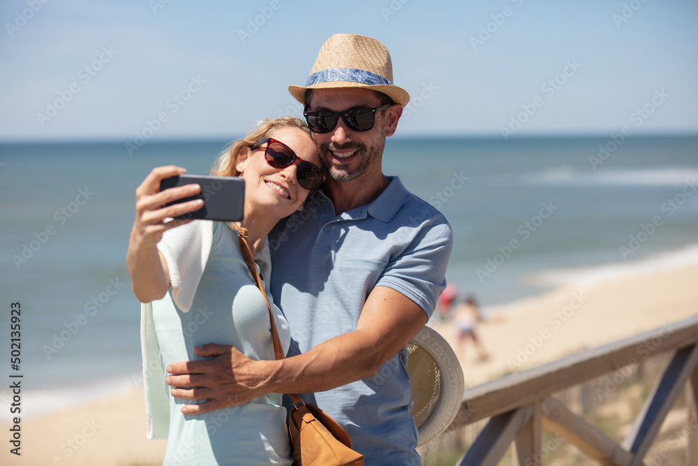 couple in love taking a selfie at a beach