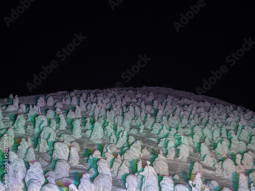 Snow monsters (soft rime) illuminated by colorful lights at night (Zao-onsen ski resort, Yamagata, Japan) photo