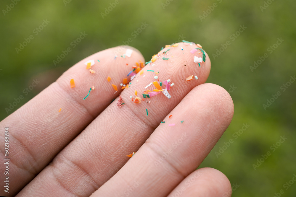 Close up side shot of microplastics lay on people hand. Concept of water pollution and global warming. Climate change idea. micro plastics concept in food and water or sea Close up side shot of microplastics lay on people hand. Concept of water pollution and global warming. Climate change idea. micro plastics concept in food and water or sea
