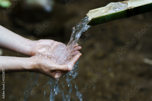 Hands with fresh, cold, potable source water on a mountain, Drinking Spring, Wooden Pipe of Fresh Potable, Unpolluted, Natural Spring Water. world water day and water save concept