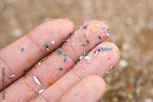 Close up side shot of microplastics lay on people hand. Concept of water pollution and global warming. Climate change idea. micro plastics concept in food and water or sea photo
