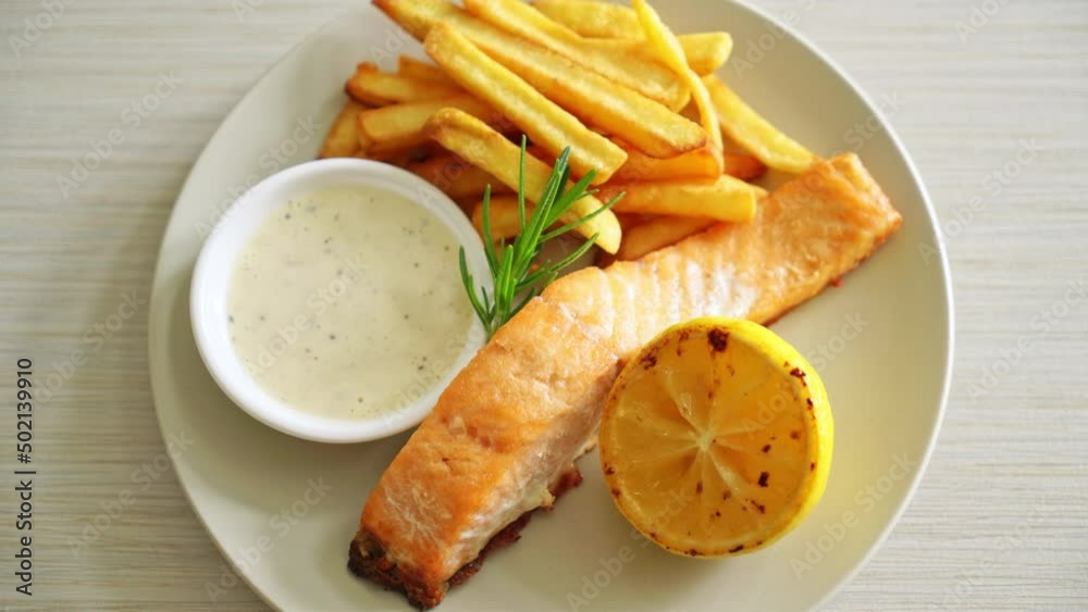 fried salmon fish and chips with lemon on plate fried salmon fish and chips with lemon on plate