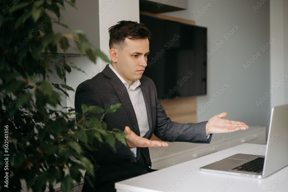 Employee looking at the screen of laptop and having questions Employee looking at the screen of laptop and having questions