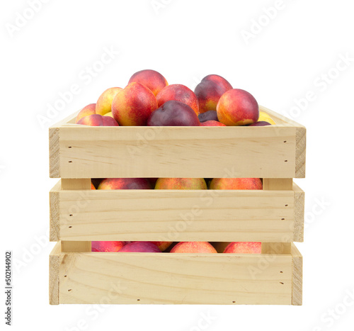 Fresh ripe nectarines in wooden box isolated on white