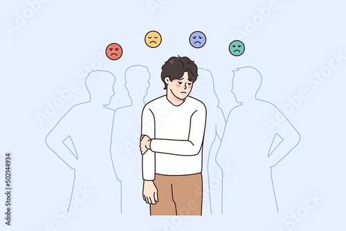 Sad guy feel lonely and uncomfortable in society. Unhappy young man suffer from solitude and loneliness in crowd, have various emotions. Frustration and depression. Vector illustration. 