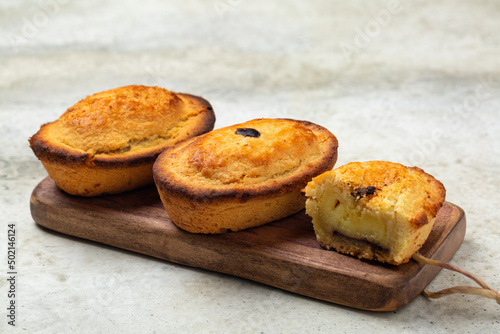 A Pasticciotto, small Italian cake, filled with egg custard cream. Called also pusties. Traditional pastry in Apulia, South Italy, typically served for breakfast. Light table surface.