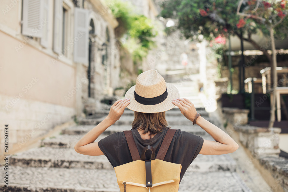 Travel concept, beautiful tourist woman walking in Kerkyra old town during vacation, cheerful student girl traveling abroad in summer, Corfu island, Greece