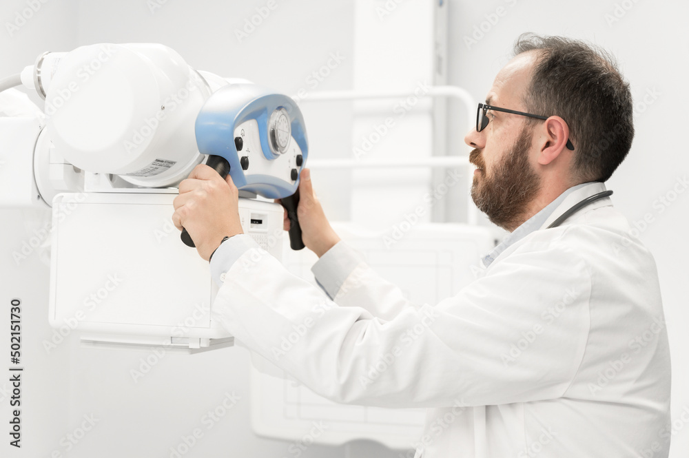Doctor operating X-ray machine in radiology department. High quality photography. Doctor operating X-ray machine in radiology department. High quality photography.