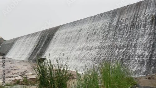 A close-up shot of the water flowing down from a Srinivasa Sagara reservoir dam creates an alluring view. photo