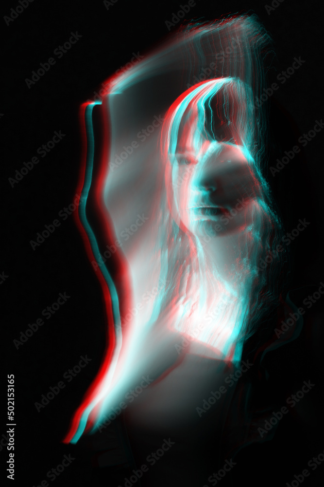Woman silhouette in bright light trails of light painting in red and blue color channel reflection split. Portrait in style of light painting. Long exposure photo. Image contains noise and motion blur Woman silhouette in bright light trails of light painting in red and blue color channel reflection split. Portrait in style of light painting. Long exposure photo. Image contains noise and motion blur
