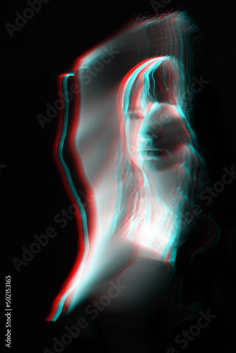 Woman silhouette in bright light trails of light painting in red and blue color channel reflection split. Portrait in style of light painting. Long exposure photo. Image contains noise and motion blur © Rytis