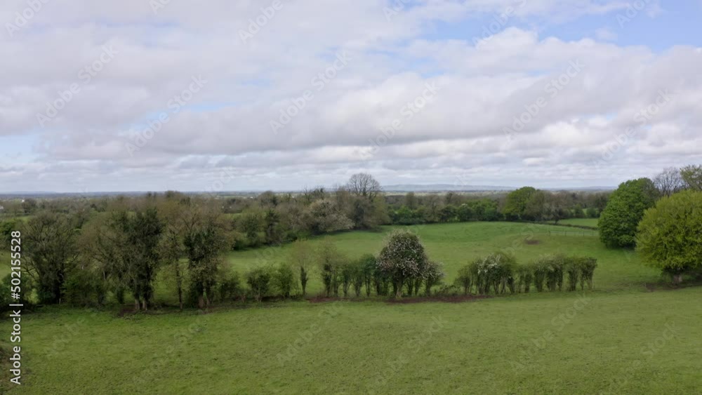Aerial view of irish green rural fields during a summer day in Ireland. Countryside and trees in background, clouds in the sky. Sense of freedom, purity, liberty, pristine, wild nature Aerial view of irish green rural fields during a summer day in Ireland. Countryside and trees in background, clouds in the sky. Sense of freedom, purity, liberty, pristine, wild nature
