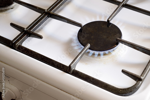 a burning gas stove on a white kitchen stove
