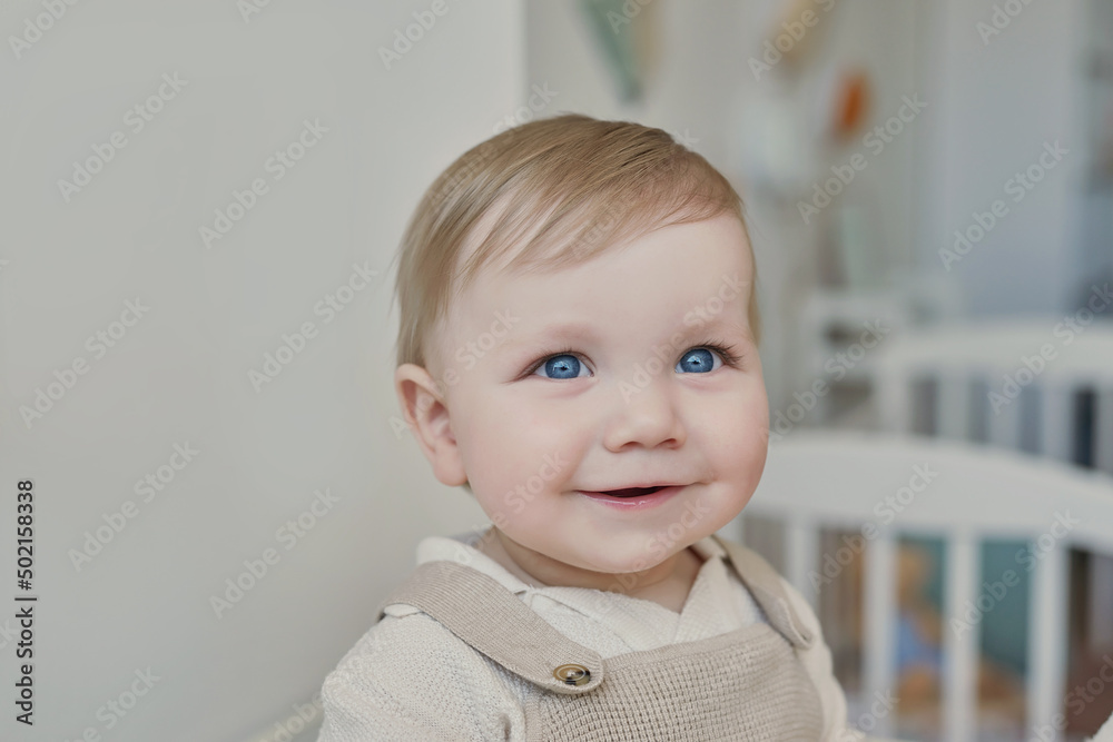 Wonderful baby boy with blue eyes. Child playing with toys in nursery. Early development, kindergarten, nursery, playroom. Children's Day, Mother's Day