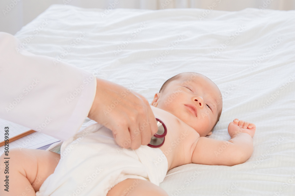 Asian newborn baby get sick sleep during examine by pediatrician doctor hand hold stethoscope, Little child in medicine hospital. Physician hand using stethoscope examining adorable infant heart. Asian newborn baby get sick sleep during examine by pediatrician doctor hand hold stethoscope, Little child in medicine hospital. Physician hand using stethoscope examining adorable infant heart.