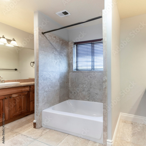 Square Master bathroom with bathtub in the middle of two vanities