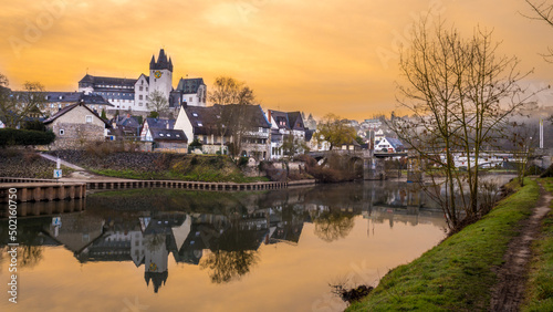 Germany, Rhineland-Palatinate, Diez, Diez Castle and surrounding houses reflecting in river Lahn at dusk