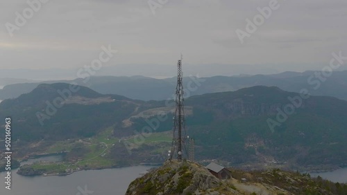 Aerial panoramic of scenic lookout, amazing Norwegian coastal landscape. Mast tower broadcasting radio waves on top of the mountain. photo