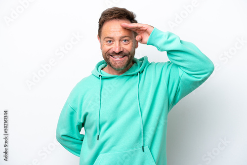 Middle age caucasian man isolated on white background saluting with hand with happy expression © luismolinero
