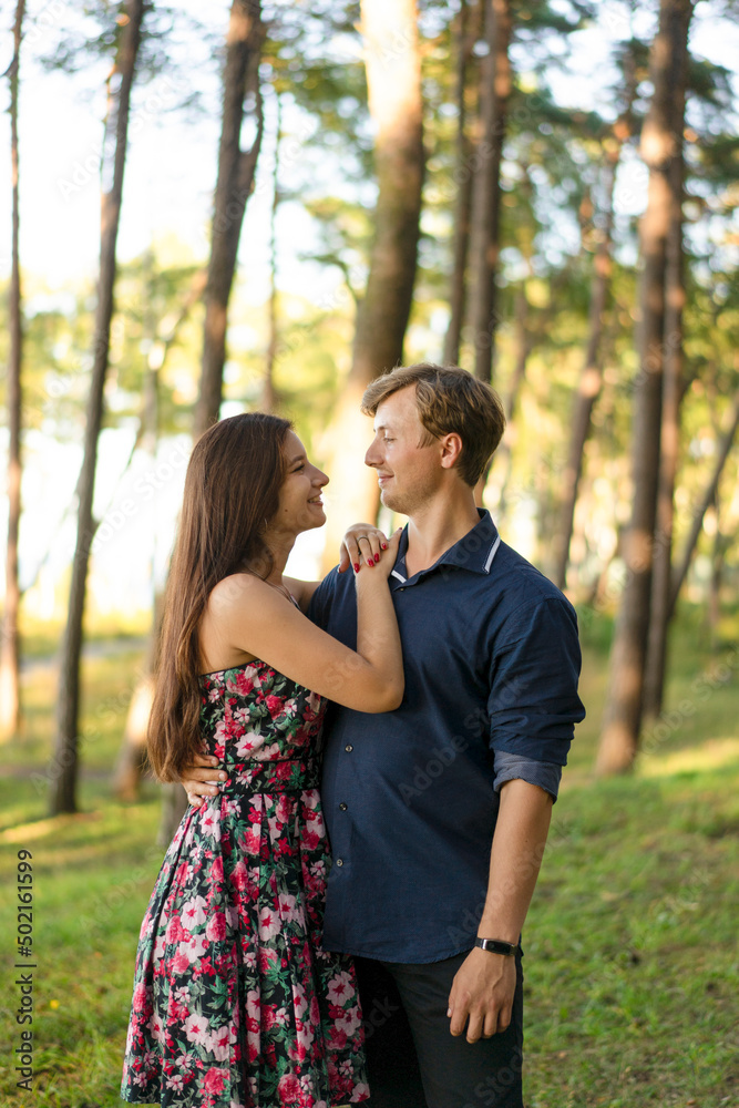 Happy young woman standing with boyfriend in forest