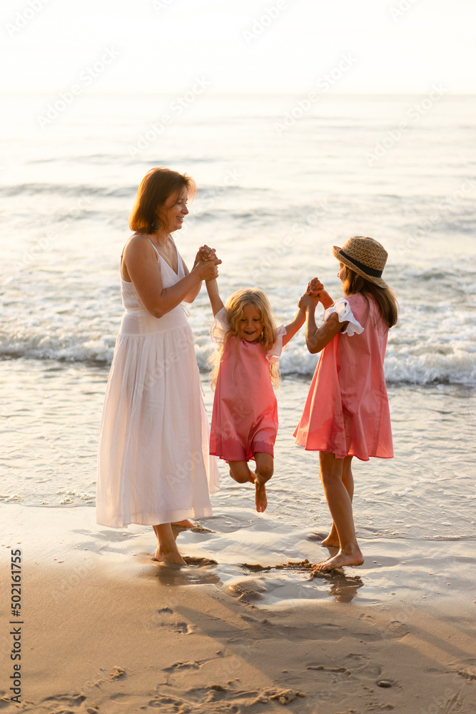 Playful mother and daughter enjoying with girl at beach Playful mother and daughter enjoying with girl at beach