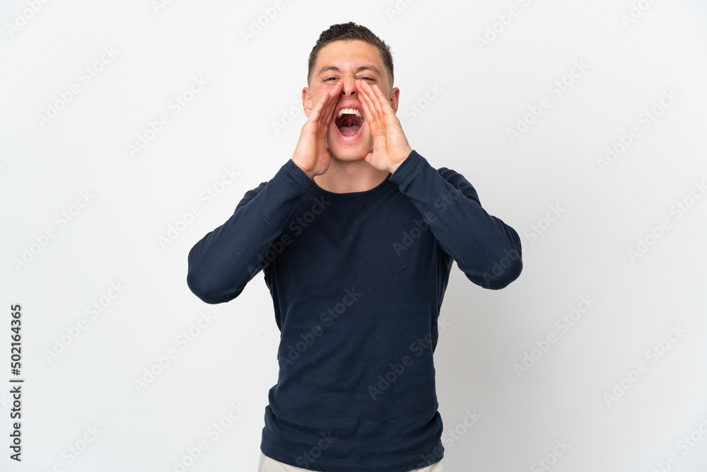 Young caucasian man isolated on white background shouting and announcing something Young caucasian man isolated on white background shouting and announcing something