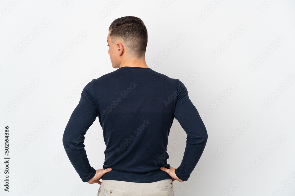 Young caucasian man isolated on white background in back position and looking side Young caucasian man isolated on white background in back position and looking side