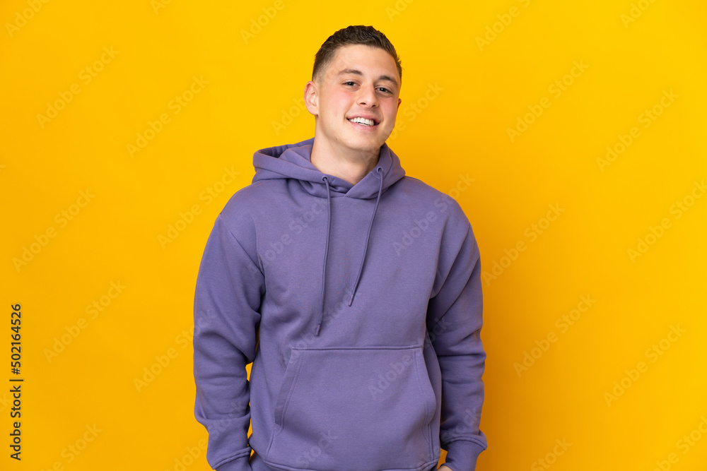 Young caucasian man isolated on yellow background laughing Young caucasian man isolated on yellow background laughing