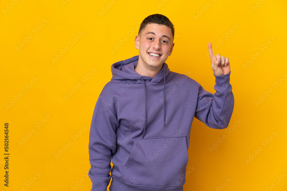 Young caucasian man isolated on yellow background pointing up a great idea Young caucasian man isolated on yellow background pointing up a great idea