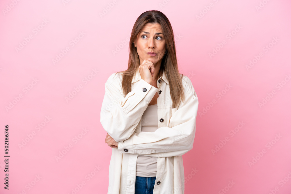 Middle age caucasian woman isolated on pink background having doubts and thinking Middle age caucasian woman isolated on pink background having doubts and thinking