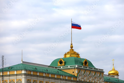Grand Kremlin Palace with Russian flag on background of blue sky with white clouds