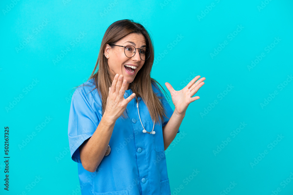 Middle age surgeon woman isolated on blue background with surprise facial expression Middle age surgeon woman isolated on blue background with surprise facial expression