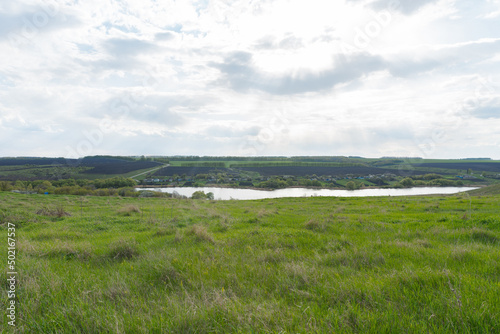 beautiful summer landscape on green hills with a pond