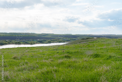 beautiful summer landscape on green hills with a pond