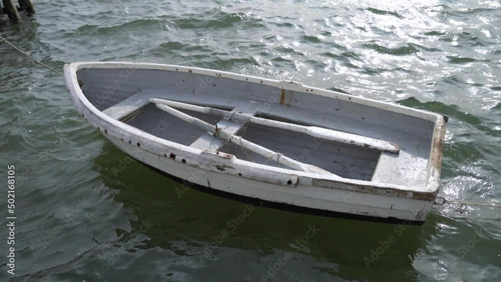 Small old fisherman's wooden empty white boat floating on the sea Small old fisherman's wooden empty white boat floating on the sea