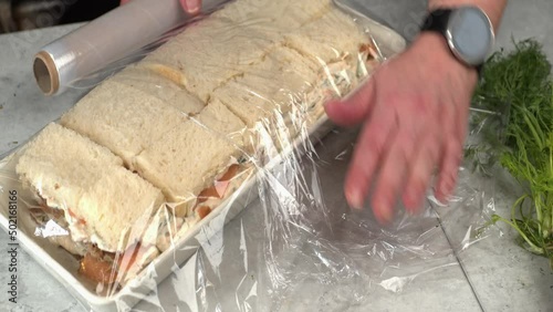 Close-up meal prep: plastic wrap added to Smorgastarta sandwich cake photo