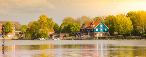 Panorama of colorful house and trees at the Leda river in Leer, Germany photo