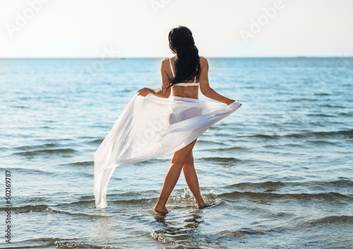 Obraz na plátně people, summer and swimwear concept - woman in bikini swimsuit with pareo on bea