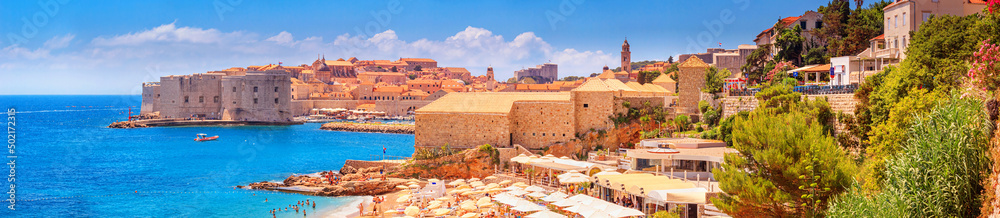 Coastal summer landscape, panorama - view of the city beach on the background of the Old Town of Dubrovnik on the Adriatic coast of Croatia
